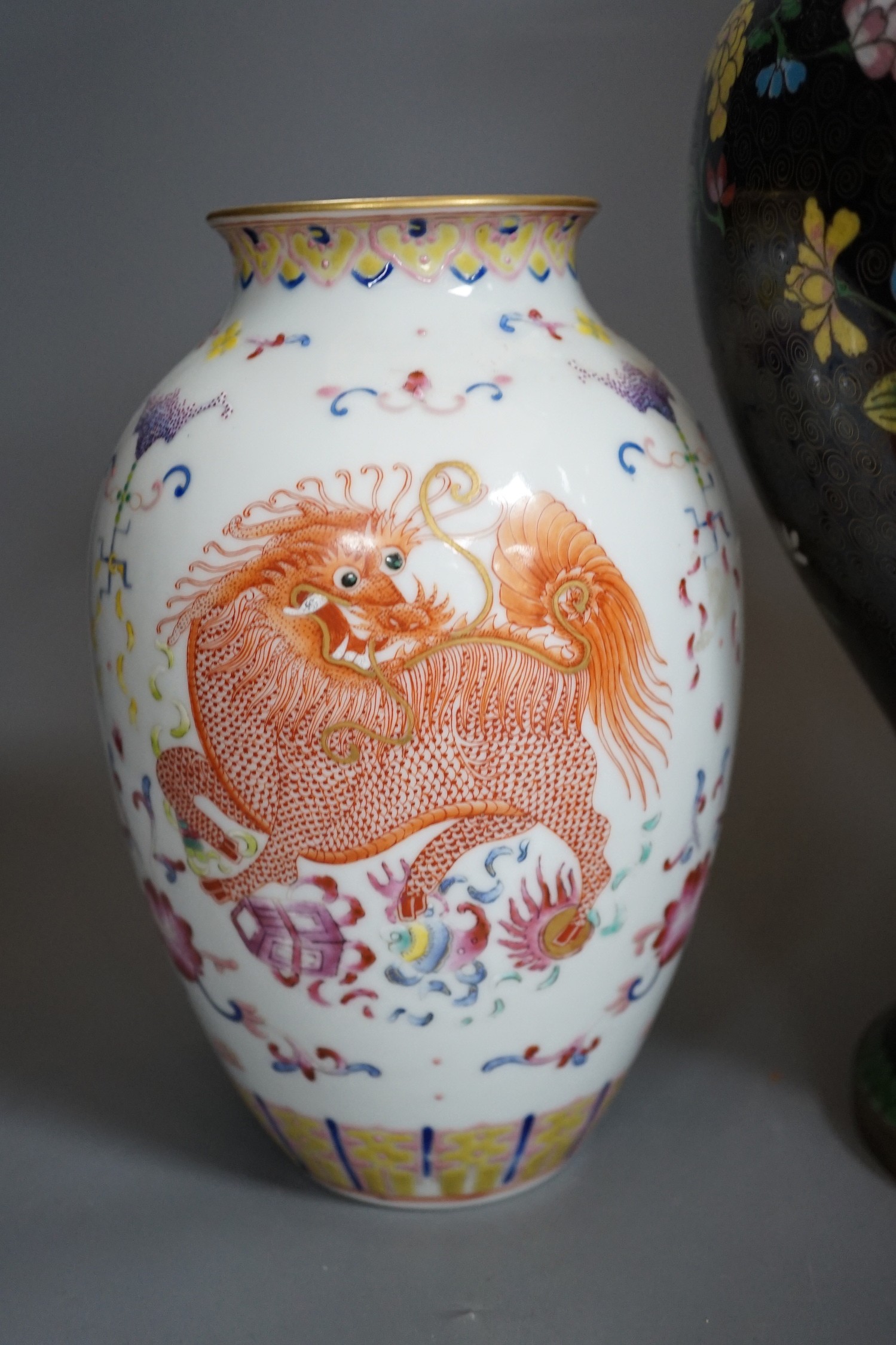 Two Chinese cloisonné enamel vases, and a porcelain ‘lion dog’ vase, tallest 33cm